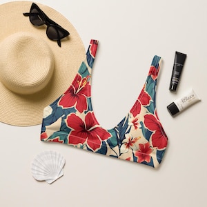May include: A red, white, and blue floral print bikini top with adjustable straps. The top has a scoop neck and a low back.