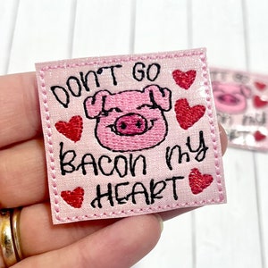 May include: Pink fabric patch with embroidered text "Don't go bacon my heart" and a cartoon pig with hearts around it.