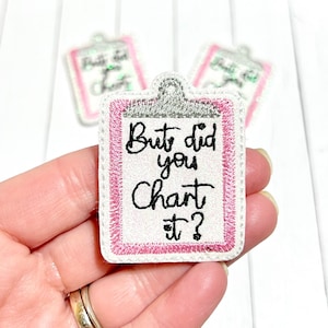 Peut inclure: Patch thermocollant brodé blanc avec une bordure rose en forme de presse-papiers. Le texte sur le patch est "But did you chart it?"