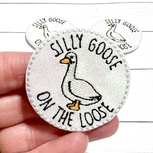 May include: White embroidered patch with a white goose and the text "Silly Goose On The Loose".