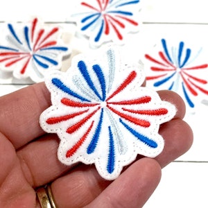 May include: Four white felt patches with red, white, and blue embroidered firework designs.