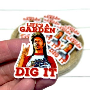 May include: A sticker with a man in a red and white shirt, with the text "LIFE'S A GARDEN DIG IT" in red. The image shows a man with a mullet. Other similar stickers are in the background.