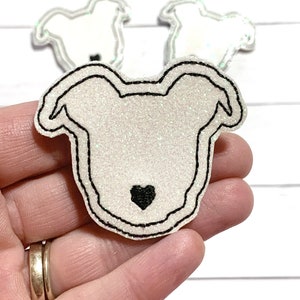 May include: White glitter iron-on patch with a black outline in the shape of a dog with a small black heart in the center.
