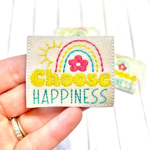 May include: A white fabric patch with a rainbow, a sun, a flower, and the text "Choose Happiness" in yellow and teal embroidery.