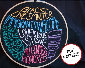 May include: Embroidered hoop art with the text "Black Lives Matter", "Immigrants Welcome", "Love is Love", "All Genders Honored", and "Everybody", in a rainbow of colors.