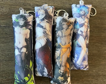 May include: Four rectangular plush keychains featuring anime-style character illustrations. Each soft fabric charm displays a unique figure with distinct color schemes including green, red, orange, and blue, all attached to silver metal key rings.