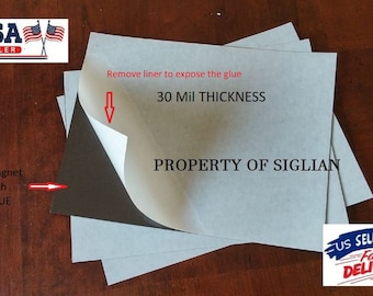 May include: A stack of three 30 mil thick magnetic sheets with adhesive backing. The sheets are gray and have the text "PROPERTY OF SIGLIAN" printed on them. The adhesive backing is white and has a liner that can be removed to expose the glue.