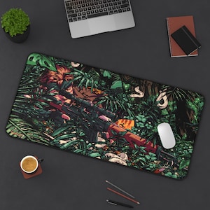 Peut inclure: Un tapis de souris vert, marron et noir avec un motif de camouflage. Une personne tient un fusil et vise à travers une lunette de visée. La personne est cachée dans le feuillage.