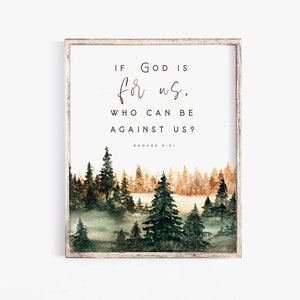 Op de afbeelding: Een ingelijst afdruk met een aquarel van een boslandschap. De afdruk bevat de quote "Als God voor ons is, wie kan dan tegen ons zijn?" met de bijbelverwijzing "Romeinen 8:31".