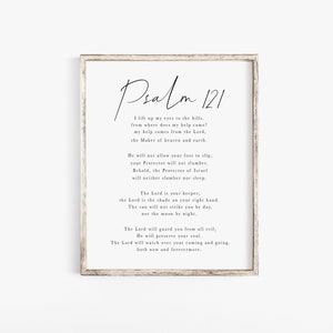 以下が含まれることがあります： 黒い筆記体で詩篇121編のテキストが書かれた額入りのプリント。プリントは白い背景と明るい茶色の木製フレームです。テキストは中央に配置され、詩のタイトルが含まれています。