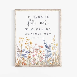 Może przedstawiać: Oprawiony wydruk ścienny z tekstem IF GOD IS FOR US, WHO CAN BE AGAINST US? ROMANS 8:31 czarnymi literami. Dolna część przedstawia akwarelową ilustrację różnych polnych kwiatów w odcieniach żółci, różu i błękitu.