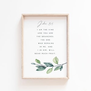 May include: A framed print with a watercolor illustration of a leafy branch and a quote from the Bible, John 15:5, which reads "I am the vine and you are the branches. The one who remains in me, and I in him, will bear much fruit."