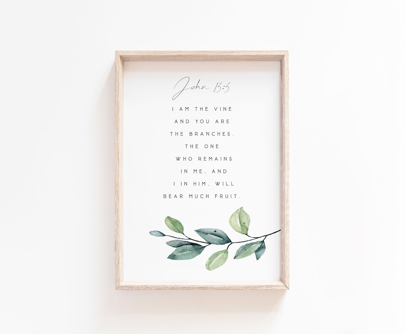 May include: A framed print with a watercolor illustration of a leafy branch and a quote from the Bible, John 15:5, which reads "I am the vine and you are the branches. The one who remains in me, and I in him, will bear much fruit."