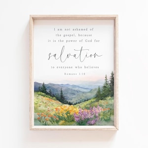 Könnte beinhalten: Gerahmter Kunstdruck mit einer Aquarelllandschaft mit Bergen, Bäumen und Wildblumen. Der Text lautet: „Ich schäme mich des Evangeliums nicht, denn es ist Gottes Kraft zur Errettung für jeden, der glaubt Römer 1:16“.
