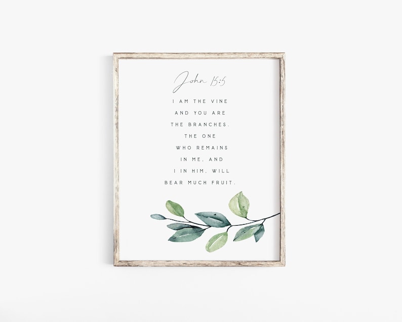 May include: A framed print with a watercolor illustration of a green leafy branch. The print features the Bible verse John 15:5, which reads "I am the vine and you are the branches. The one who remains in me, and I in him, will bear much fruit."