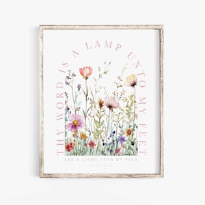 May include: A framed wall art print featuring a watercolor illustration of wildflowers in shades of pink, orange, and purple. The text reads: THY WORD IS A LAMP UNTO MY FEET AND A LIGHT UNTO MY PATH. Psalm 119:105 is printed at the bottom.
