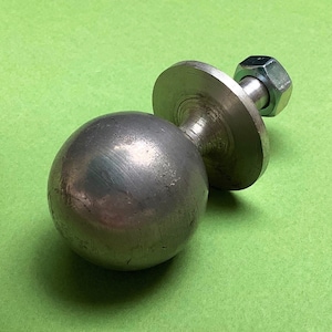 Può includere: Una sfera di metallo argentata con una base piatta e un'asta filettata con un dado. La sfera è fissata alla base con un'asta filettata.