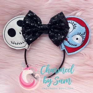May include: Black sequin bow headband with a white and black Jack Skellington character on one side and a blue and red Sally character on the other side.  The headband is black.  The text "Charmed by Sam" is visible below the headband.