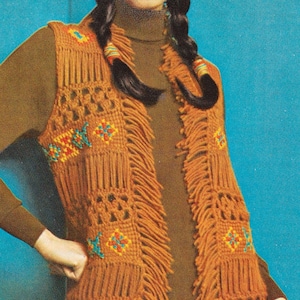 May include: A brown crocheted vest with fringe and colorful geometric patterns. The vest has a V-neck and is worn over a brown turtleneck.