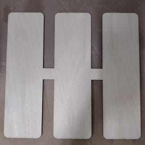 Puede incluir: Tres paneles rectangulares de madera con recortes en el medio, creando un patrón repetitivo.