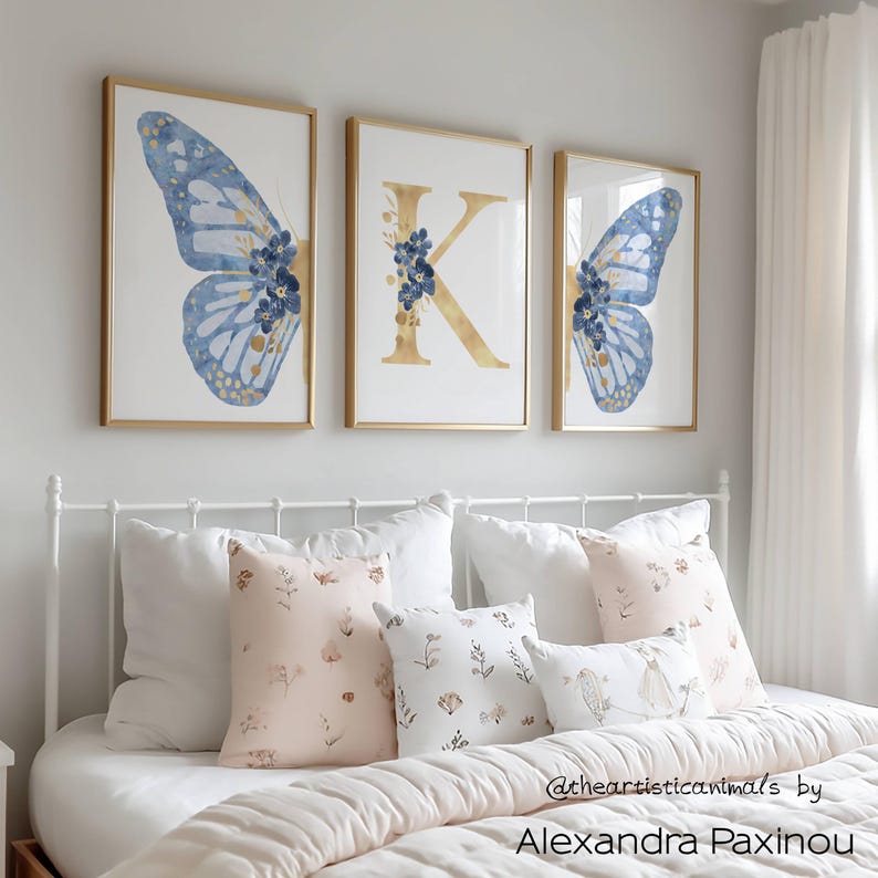 Set of 3 blue and gold butterfly prints, personalized with a letter of your choice, unframed, the picture shows how the triptych looks once framed in a girl bedroom over the bed, displayed size A3 and displayed initial K