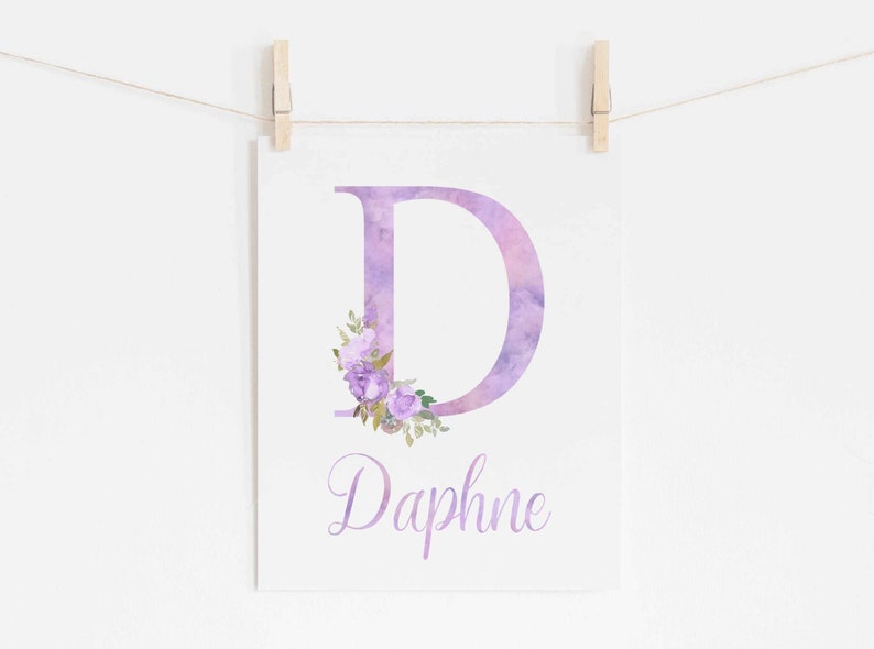 Op de afbeelding: Paarse aquarelletter D met een bloemenontwerp en de naam Daphne eronder gedrukt.