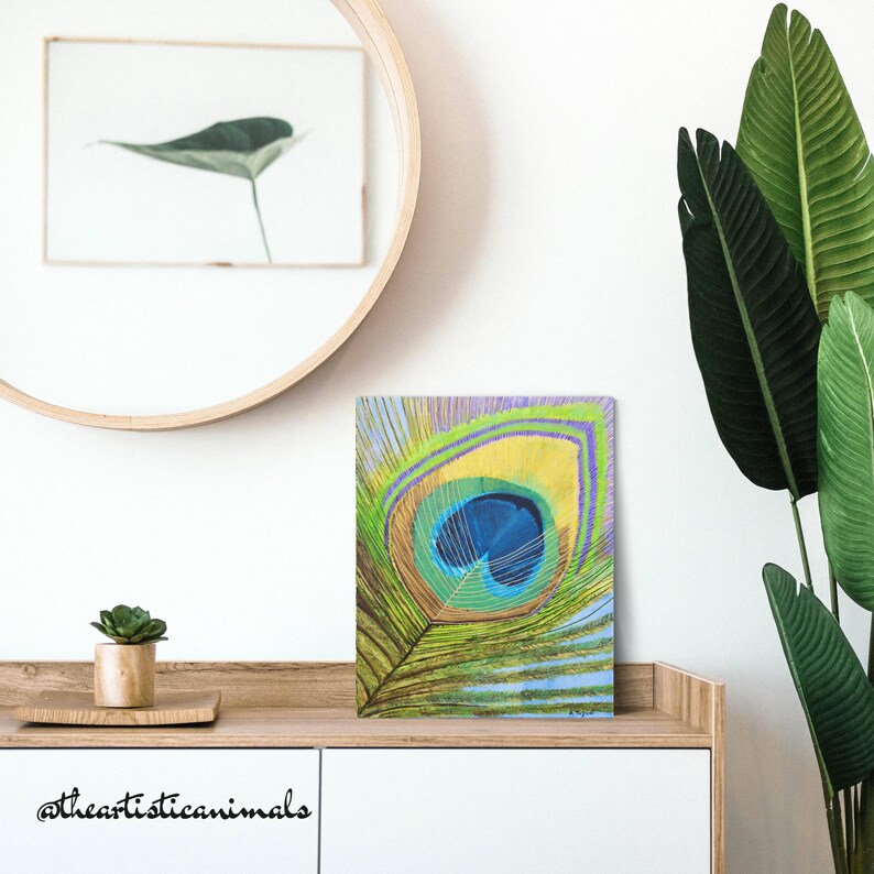 Green and blue peackock feather painting on stretched canvas, ready to be hang, size 16x20 inches (40x50 cm), the picture shows how the artwork looks in a bedroom on a console
