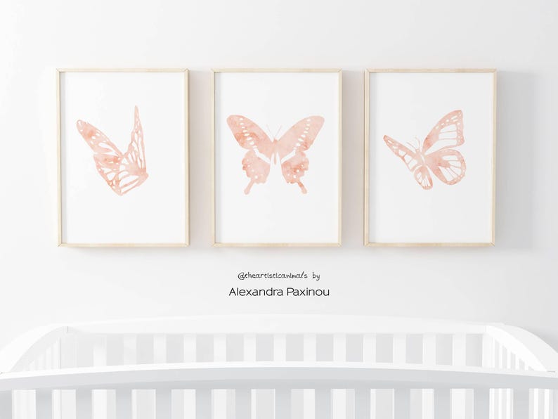 printable butterfly prints set of 3 whole blush pink butterflies. The picture shows how the triptych looks once framed in a nursery over the baby crib. displayed size A4