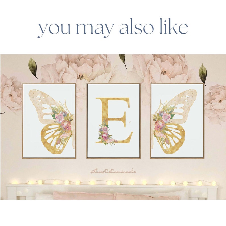 May include: Three framed art prints with gold butterfly wing and letter "E" designs. The butterfly wings and letter are adorned with floral arrangements in pink, purple, and white. The background features a floral pattern and the text "you may also like".