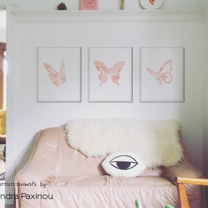 printable butterfly prints set of 3 whole blush pink butterflies. The picture shows how the triptych looks once framed in a living room above sofa, displayed size 16x20 inches