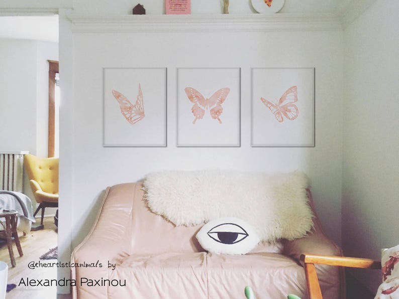 printable butterfly prints set of 3 whole blush pink butterflies. The picture shows how the triptych looks once framed in a living room above sofa, displayed size 16x20 inches