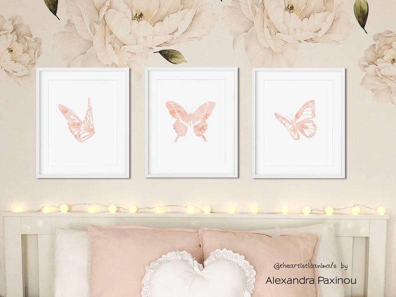 printable butterfly prints set of 3 whole blush pink butterflies. The picture shows how the triptych looks once framed in a bedroom over the bed. displayed size 8x10 inch