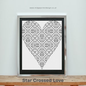 May include: Black and white cross-stitch design of a heart with a geometric pattern. The design is framed in a black frame with a silver border. The text "Star Crossed Love" is below the frame.