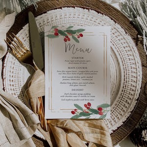 May include: A Christmas-themed menu with a gold border and watercolor illustrations of red berries and green leaves. The menu includes a starter, main course, and dessert. The text reads: "Menu, Starter, Penne rigati with pancetta capers, diced tomatoes & cheese, Main Course, Petite filet mignon bacon-wrapped filets with point reyes blue cheese butter & garlic mashed potatoes, Herb roasted chicken, garlic mashed potatoes, lemon zest, rosemary jus, Alaskan king salmon, pan seared salmon, chili glaze, broccoli, Dessert, Dark chocolate sponge pudding with chocolate sauce & vanilla ice cream, Iced raspberry parfait with berry sauce."