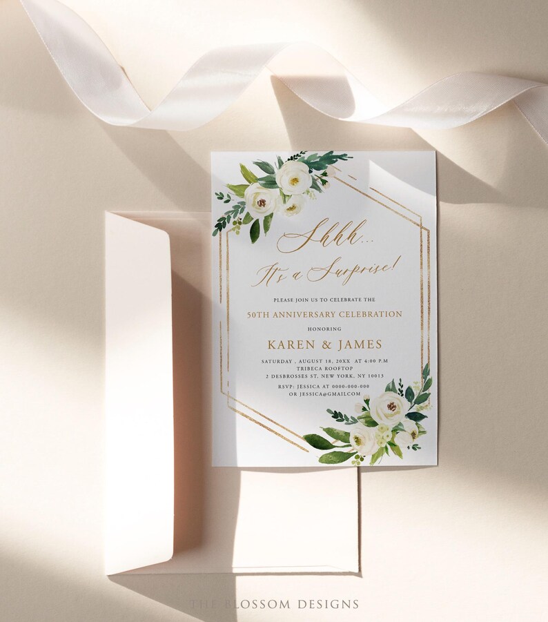 Puede incluir: Una tarjeta de invitaci&oacute;n blanca con detalles geom&eacute;tricos dorados y arreglos florales. El texto dice "Shhh... It's a Surprise!" y anuncia una celebraci&oacute;n del 50 aniversario para Karen & James. Incluye un sobre y una cinta.