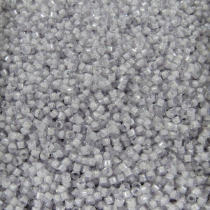 Puede incluir: Una gran cantidad de pequeñas cuentas de vidrio transparentes e iridiscentes. Las cuentas son redondas y tienen un ligero brillo.