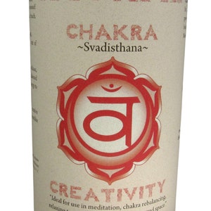 May include: Red candle with a white label that says "Sacral Chakra ~Svadisthana~" and a red symbol with the word "Creativity" below it. The label also says "Ideal for use in meditation, chakra rebalancing relaxing to music, or sitting in your sacred space. Essential Oil Fragrance Blend: ylang-ylang, sandalwood Crystal Journey Candles"