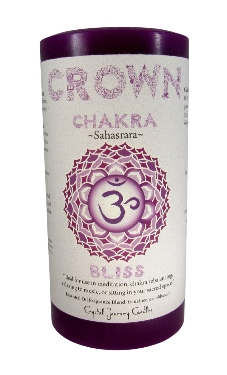 May include: Purple candle with a white label that says "Crown Chakra ~Sahasrara~" and features a purple and white mandala with the symbol "Om" in the center. The label also says "Bliss" and "Ideal for use in meditation, chakra rebalancing, relaxing to music, or sitting in your sacred space. Essential Oil Fragrance Blend: frankincense, olibanum Crystal Journey Candles"