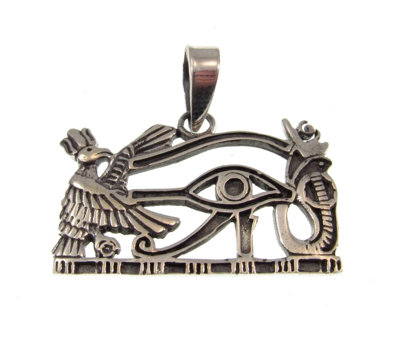 May include: Silver pendant featuring the Eye of Horus, a symbol of protection and good health in ancient Egyptian mythology. The pendant depicts the eye surrounded by a cobra and a hawk, with a loop at the top for attaching a chain.
