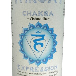 May include: Blue candle with a white label that says "Throat Chakra ~Vishuddha~" and features a blue and white symbol. The label also says "Expression" and "Ideal for use in meditation, chakra rebalancing, relaxing to music, or sitting in your sacred space. Essential Oil Fragrance Blend: neroli, sage Crystal Journey Candles".