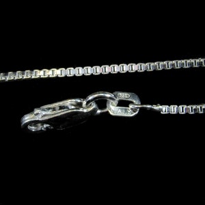 May include: A silver chain necklace with a lobster clasp. The clasp is marked "925 ITALY".