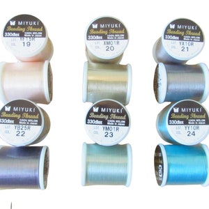 May include: Six spools of Miyuki Beading Thread made of 100% nylon, 330dtex. The spools are arranged in two columns of three, featuring various colors including light pink, pale yellow, grey, purple, light green, and bright blue.