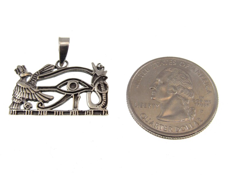 May include: Silver pendant featuring the Eye of Horus, an ancient Egyptian symbol of protection and good health. The pendant is about the size of a US quarter.