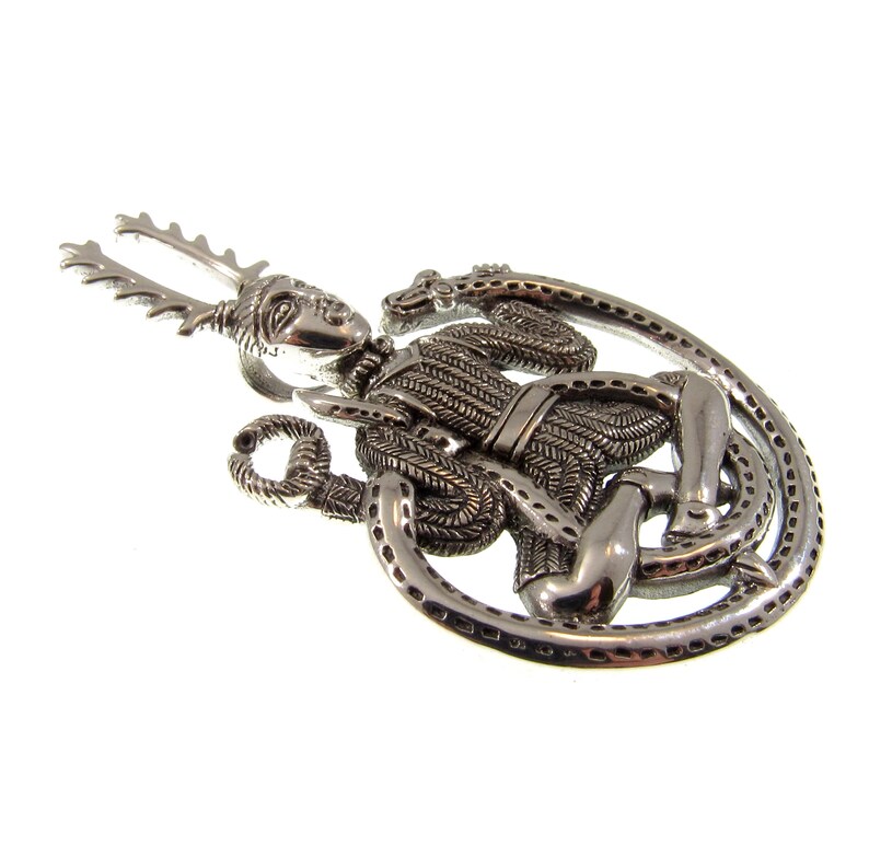 Pu&ograve; includere: Pendente in argento raffigurante una figura con corna, seduta in un cerchio con un serpente avvolto attorno ad essa.