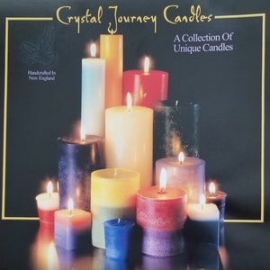 May include: A collection of candles in various colors and sizes, including red, blue, yellow, and black. The candles are arranged in a pyramid shape and are lit, creating a warm and inviting atmosphere. The text "Crystal Journey Candles" and "A Collection of Unique Candles" is visible at the top of the image.