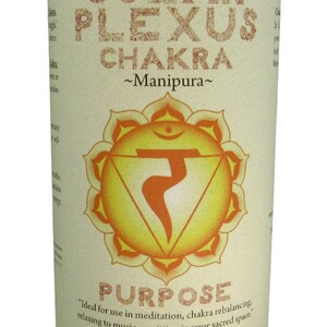 May include: Yellow candle with a white label that says "Solar Plexus Chakra ~Manipura~" and features a yellow and orange chakra symbol. The label also says "Purpose" and "Ideal for use in meditation, chakra rebalancing, relaxing to music, or sitting in your sacred space. Essential Oil Fragrance Blend: lavender, rosemary Crystal Journey Candles."