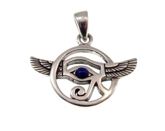 May include: Silver pendant with a blue lapis lazuli stone in the center of the Eye of Horus symbol. The pendant is surrounded by a circle and has wings on either side.