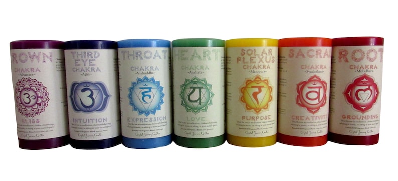 May include: Seven chakra candles, each with a different color and symbol. The candles are labeled with the name of the chakra, the Sanskrit symbol, and the corresponding chakra benefit. The colors are red, orange, yellow, green, blue, indigo, and violet.