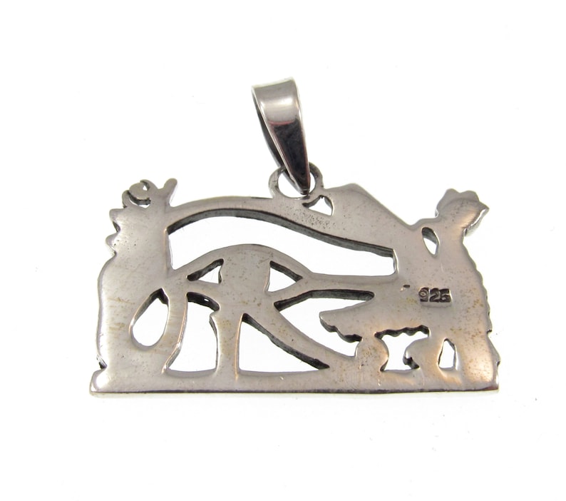 May include: Silver pendant featuring an intricate cutout design of an eye with wings. The back of the pendant is stamped with "925", indicating it is made of sterling silver.