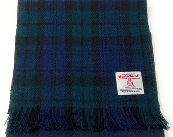 May include: A blue and green plaid scarf with fringed edges. The scarf is made of Harris Tweed, a handwoven cloth from the Outer Hebrides of Scotland. The label reads "HAND WOVEN CLOTH Harris Tweed HARRIS TWEED OUTER HEBRIDES OF SCOTLAND 100% PURE NEW WOOL."